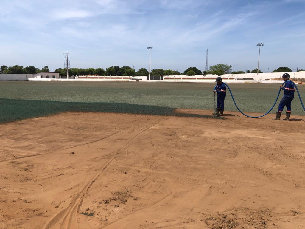 Equipe aplicando hidrossemeadura em campo esportivo